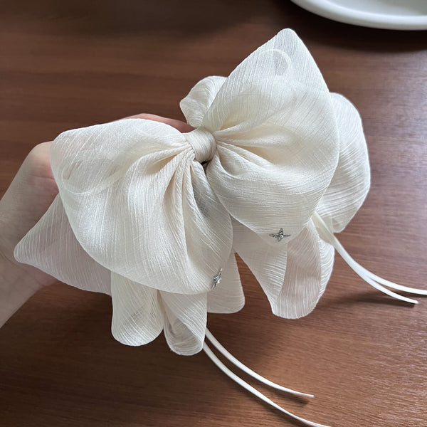 Exquisite ethereal tulle ribbon bow spring clip with a lightweight and delicate texture.